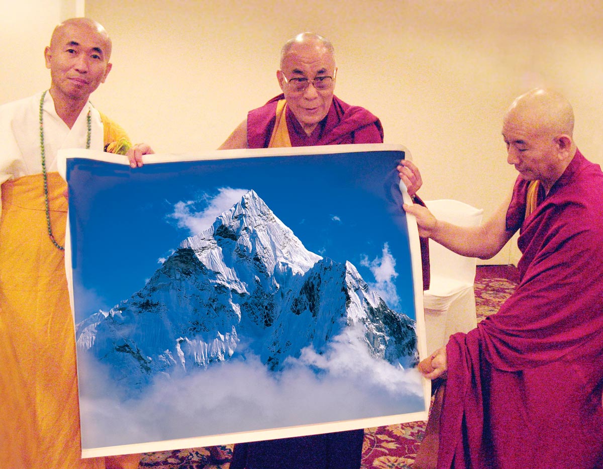 Далай Лама торжественно демонстрирует полученную в подарок от представителей Евросоюза фотографию святой горы Ама-Даблам, выполненную Сергеем Мельникофф, aka, MFF. Слева стоит легендарный японский монах Тэрасава Дзюнсэй, официальный хранитель мощей Будды. Тэрасава Дзюнсэй возглавлял крупнейшие протестные антивоенные акции в Европе в 80-х годах XX века. Индия, Нью-Дели. 2007 год.
